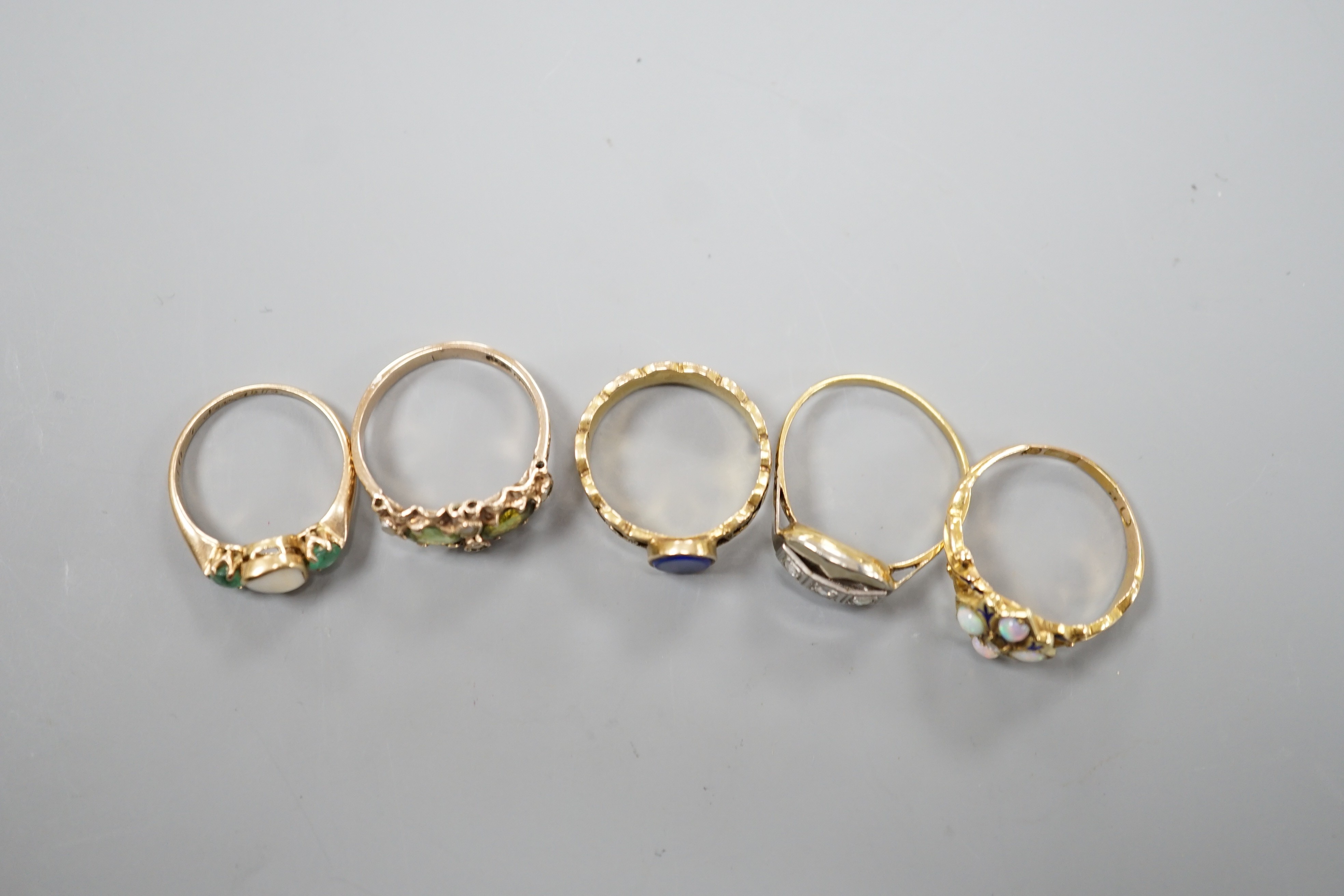 Five assorted early 20th century and later gem set rings, including 15ct white opal and enamel size O, gross weight 2.6 grams, a 585 emerald and white stone ring, gross 2 grams and three others including 9ct gold, gross